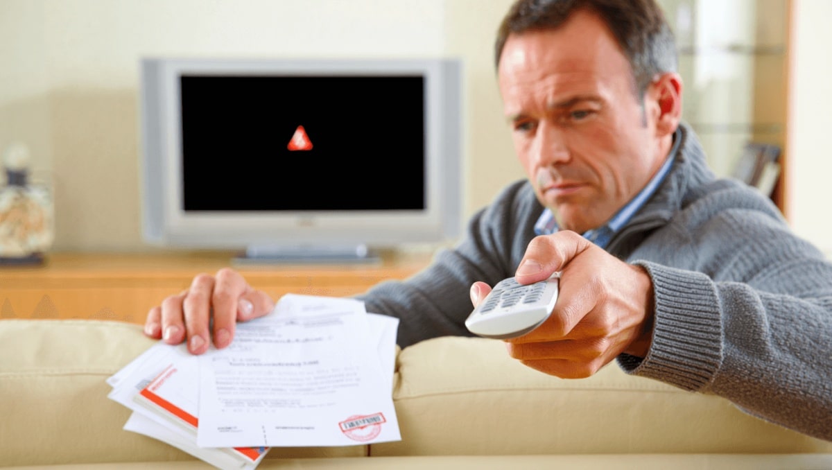 Fernbedienung und Fernseher im Hintergrund