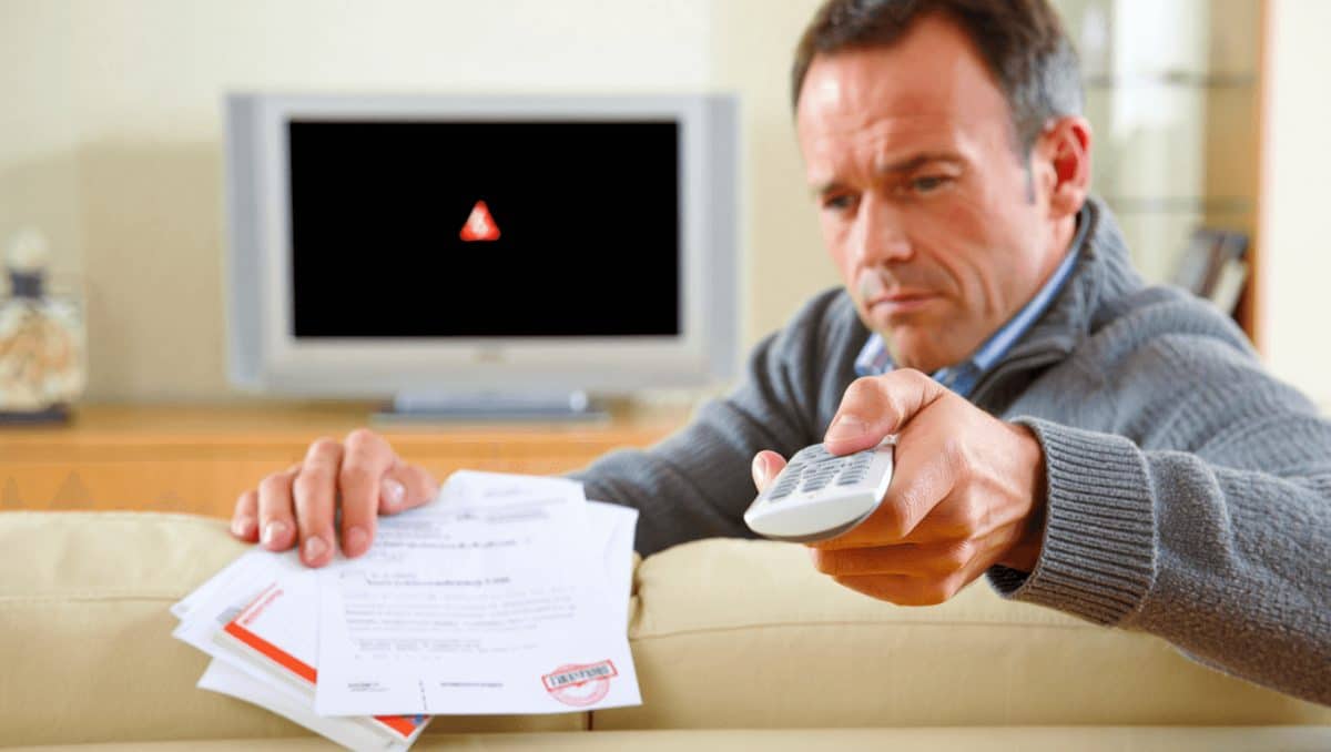 Fernbedienung und Fernseher im Hintergrund