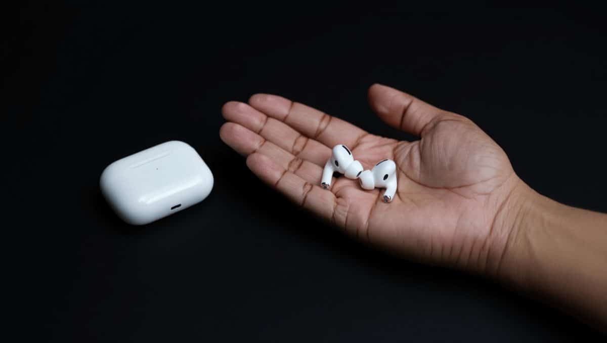 AirPods Pro mit Case im Vordergrund, geblurrter Kopf im Hintergund