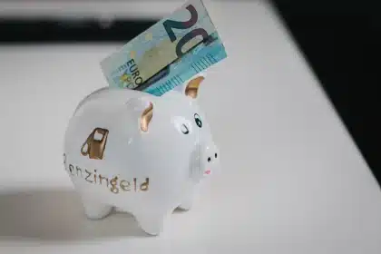 Münzen werden in ein transparentes Sparschwein mit Kindersilhouette eingezahlt