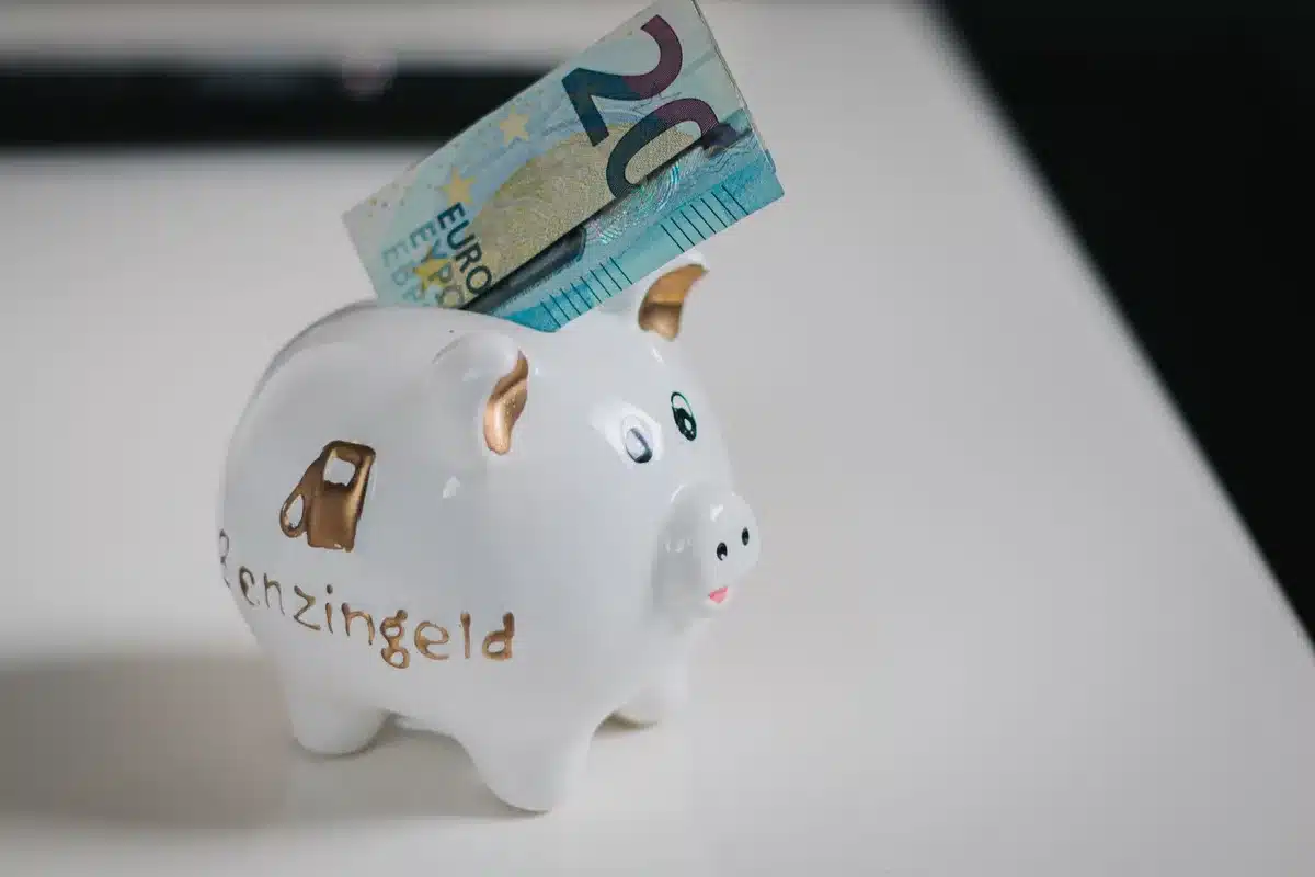 Münzen werden in ein transparentes Sparschwein mit Kindersilhouette eingezahlt