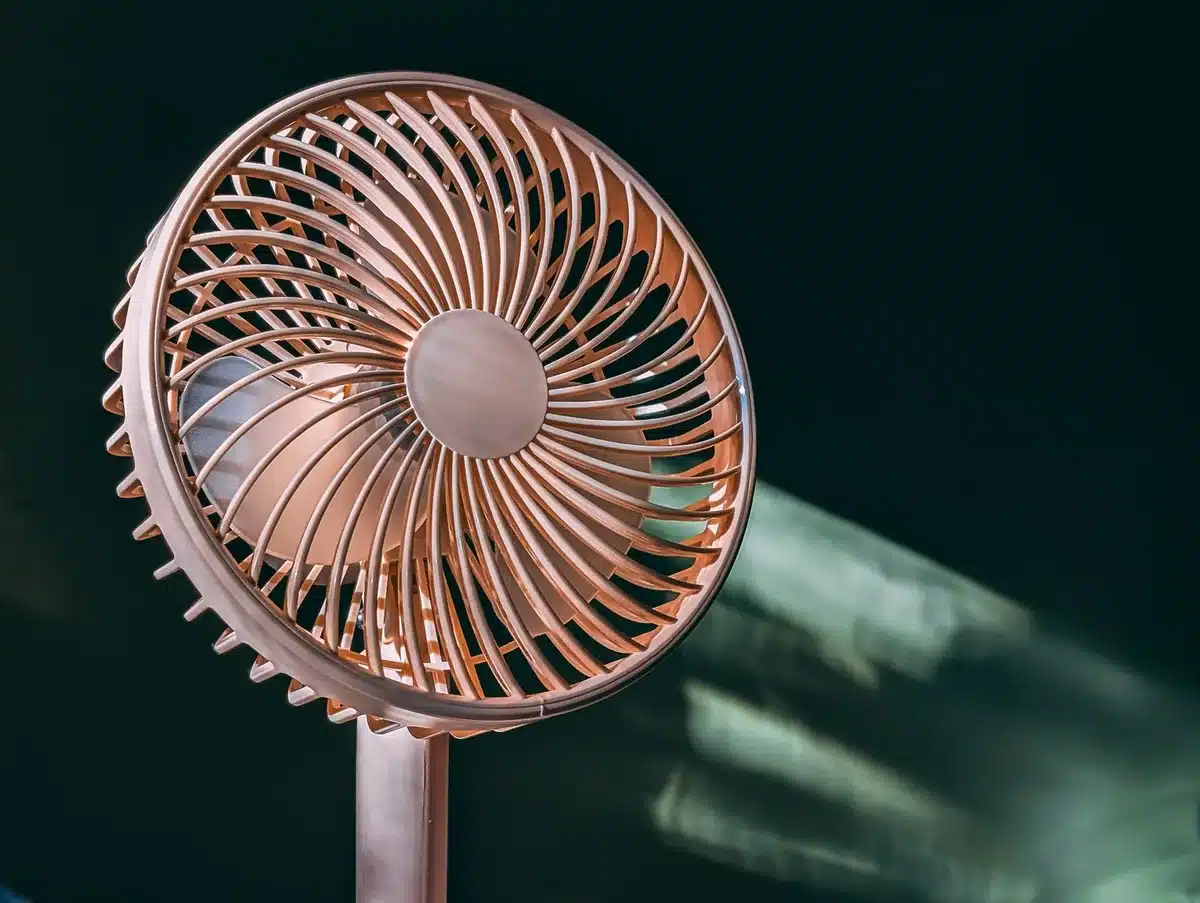 Kompakter tragbarer Akku-Ventilator in der Hand mit sichtbarem Luftstrom