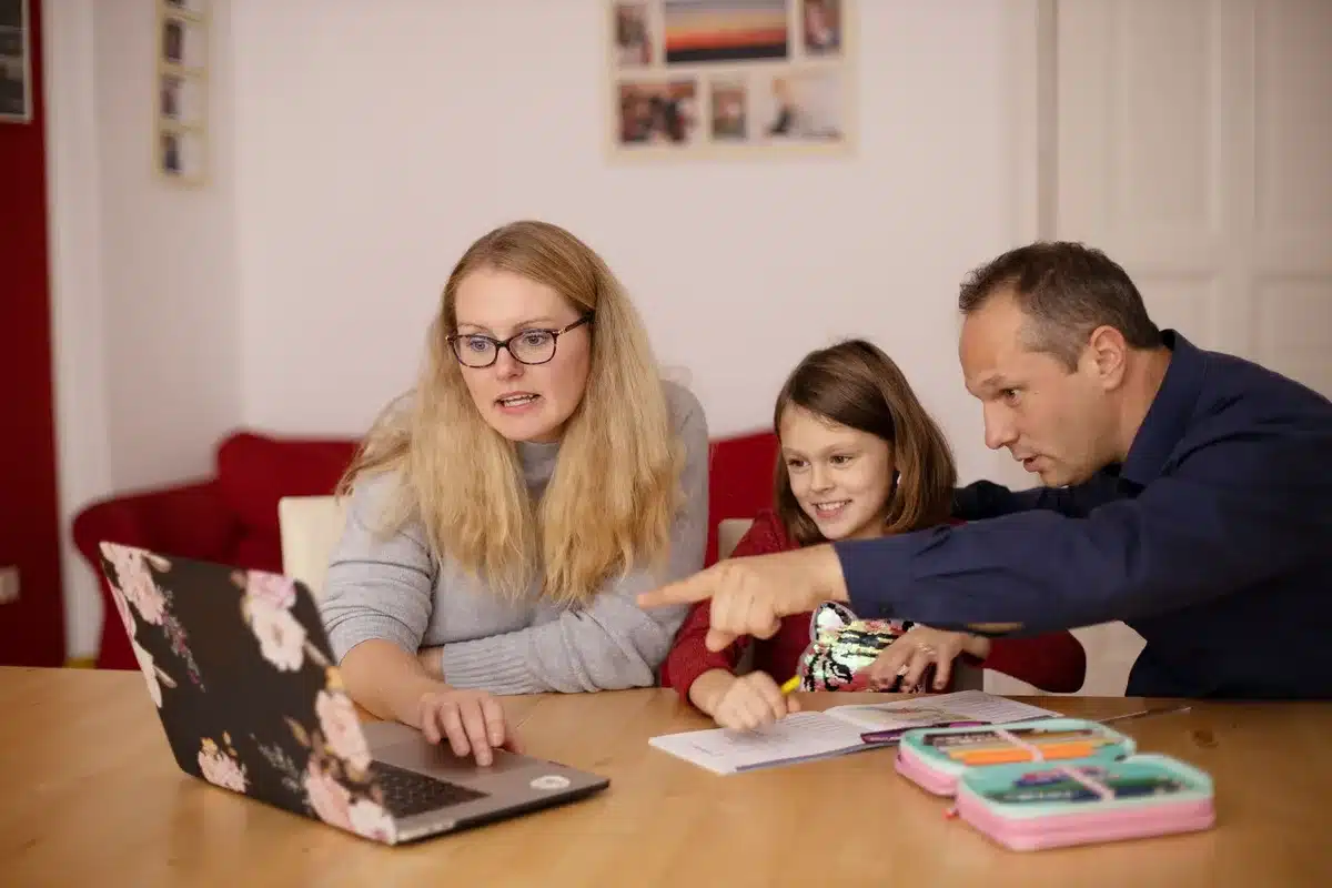 Eltern und Kind bei den Hausaufgaben am Computer