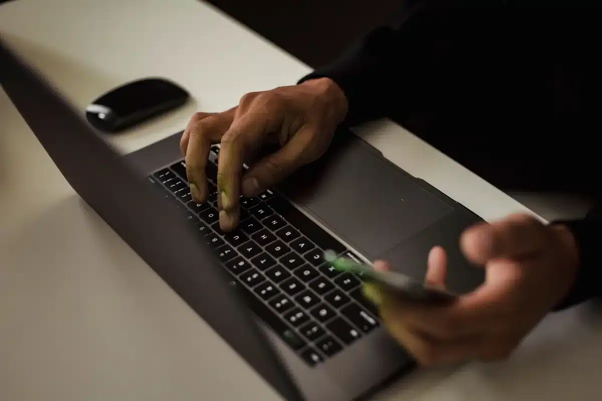 Hände über einer Tastatur mit verdächtiger E-Mail auf dem Bildschirm