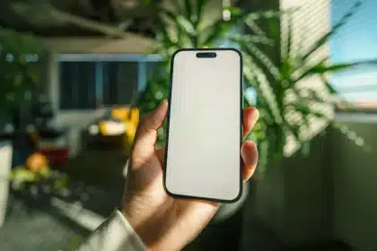 Hände halten ein modernes Smartphone mit leuchtendem Display und Kamera-Details