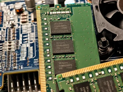 Defekte RAM-Module und Rechnungsunterlagen auf einem Schreibtisch neben einem Laptop