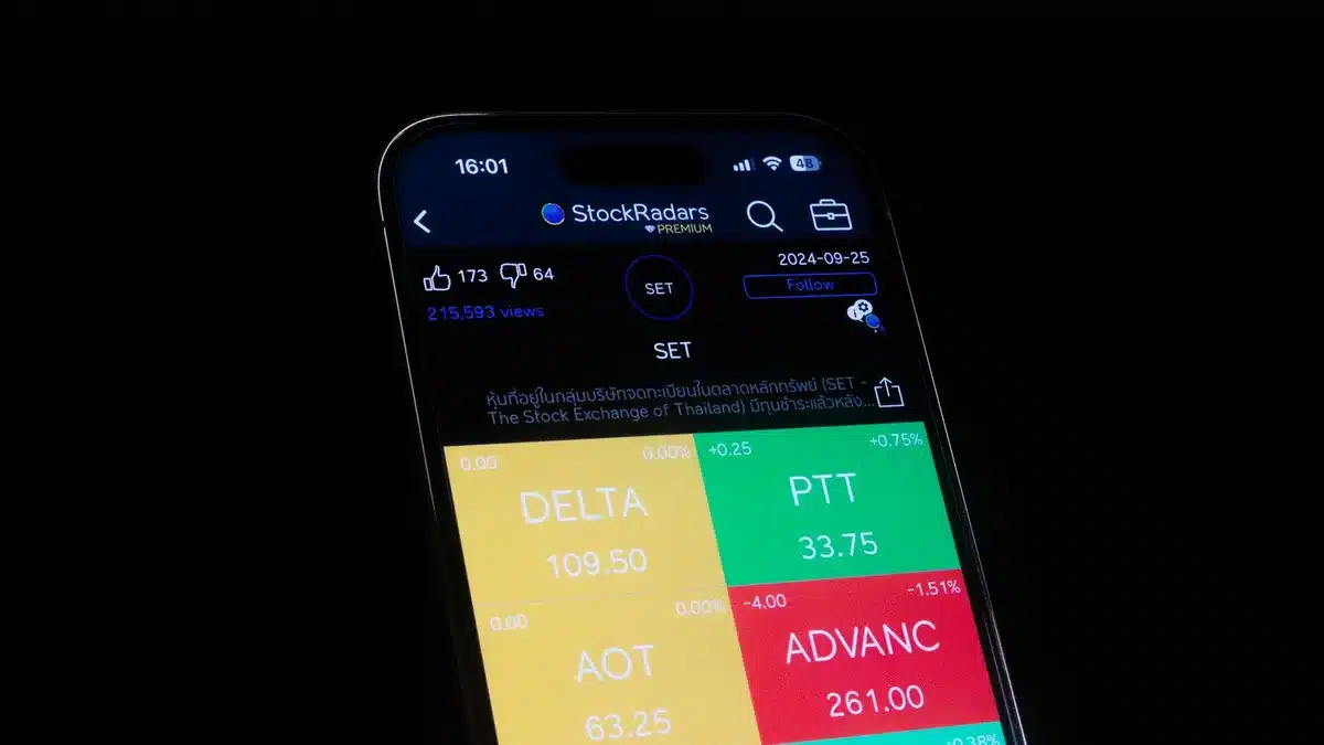 Junge Anleger nutzen eine Broker-App auf ihrem Smartphone zum mobilen Wertpapierhandel