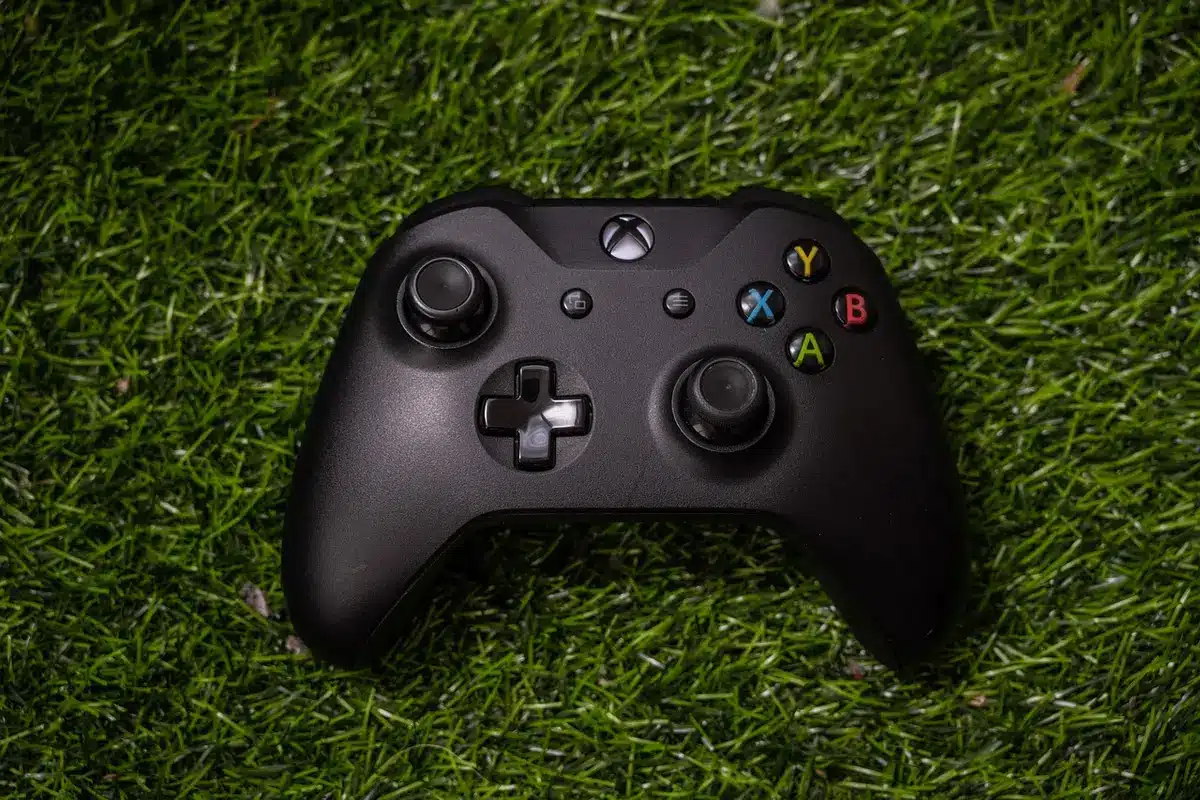 Anonyme Silhouette in einer Gaming‑Lounge mit Headsets und Controller