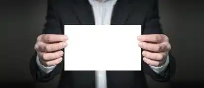 Anonyme Hände halten ein Globus-Modell über Schreibkarten auf einem Tisch