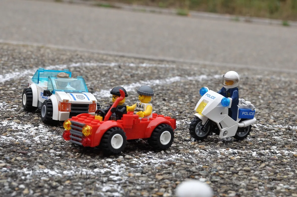 Auswahl kleiner LEGO-Fahrzeuge und Minifiguren auf hellem Hintergrund