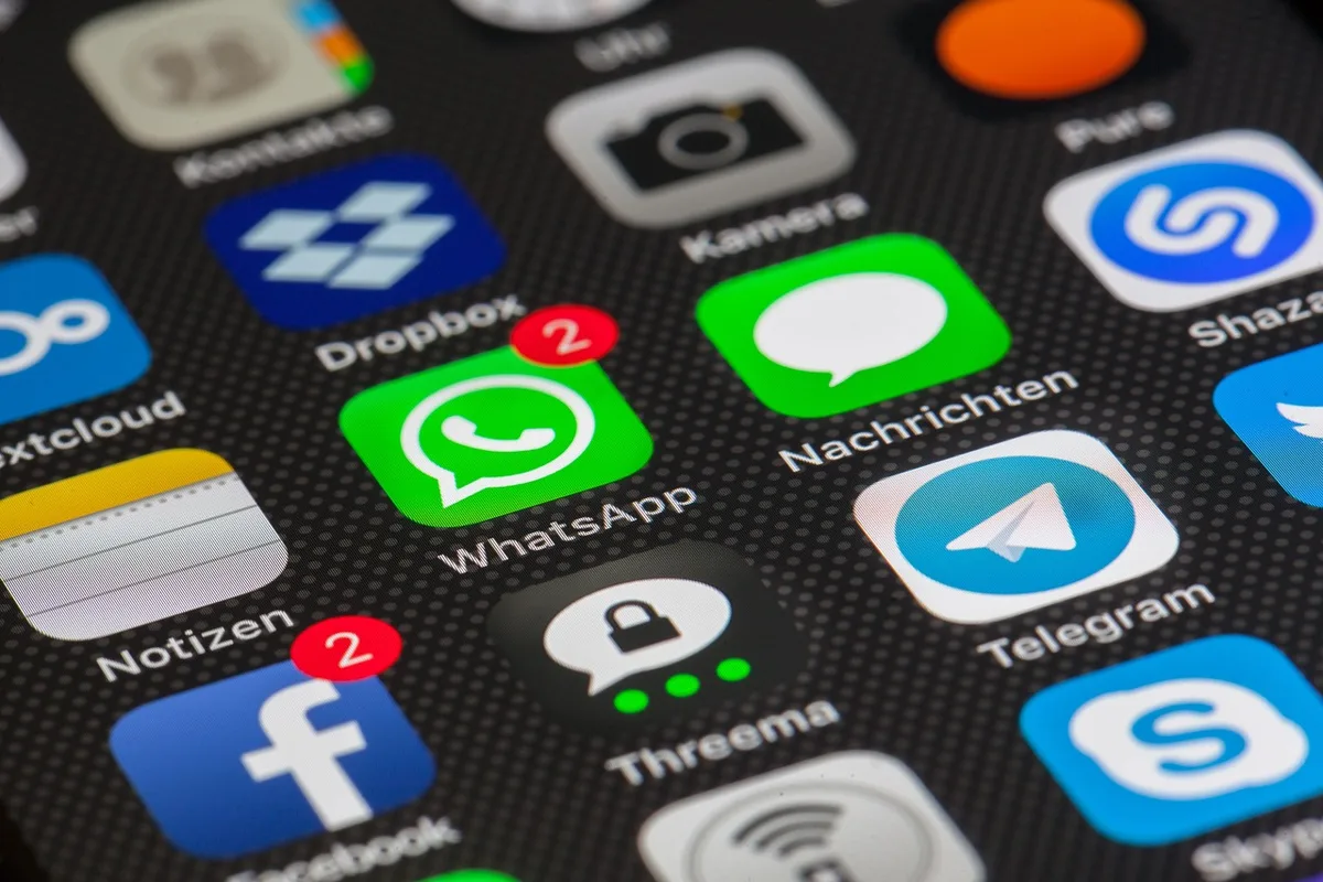 Nahaufnahme einer Hand mit Smartphone, App mit Coupons sichtbar
