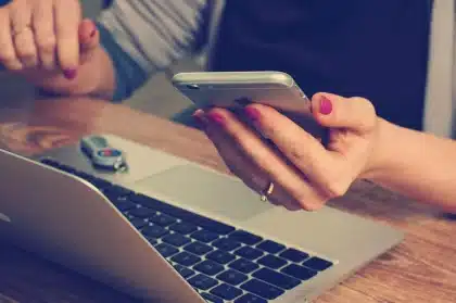 Over‑Ear‑Kopfhörer und Laptop auf dem Klapptisch eines Zuges, weiches Tageslicht