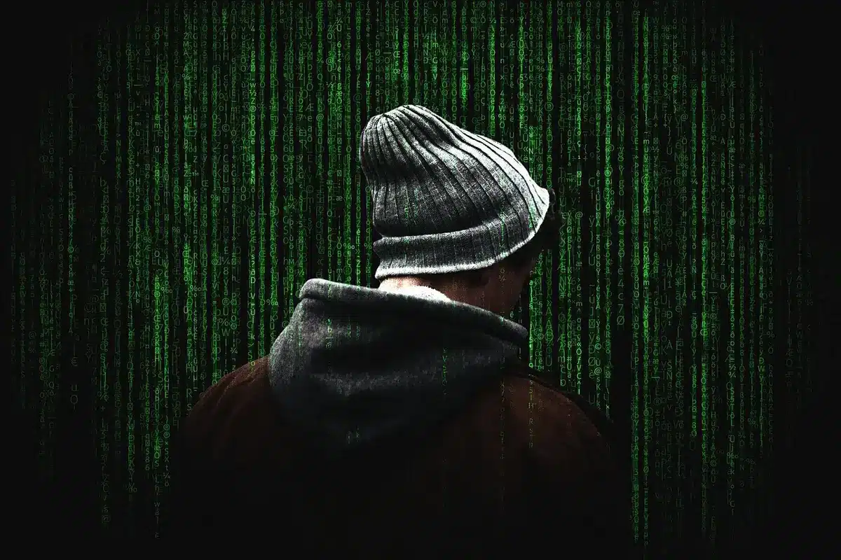 Anonyme Hände tippen auf einem Laptop, Netzwerkdiagramm auf Monitor im Hintergrund