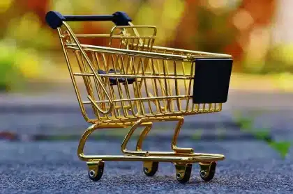Kinderhände halten bunte Sammelsticker in einem Supermarkt mit Einkaufswagen