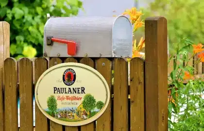 Hände öffnen eine neutrale Sammel‑Tin‑Box, Spielkarten und Hüllen auf einem Tisch