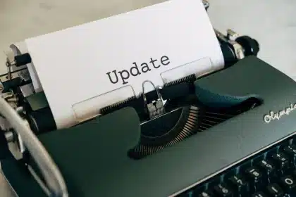 Hände halten Smartphone mit sichtbaren Systemeinstellungen und Update-Hinweis