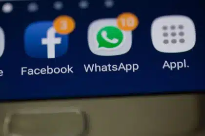 Hand mit Smartphone zeigt Lebensmittel-App mit Rabattangebot auf Tisch