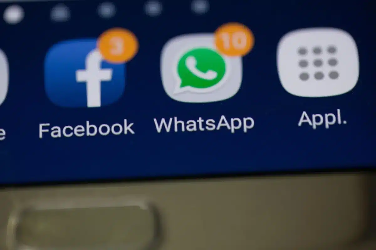 Hand mit Smartphone zeigt Lebensmittel-App mit Rabattangebot auf Tisch