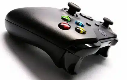 Silhouetten von Händen an Controllern vor einem unscharfen Studioflur